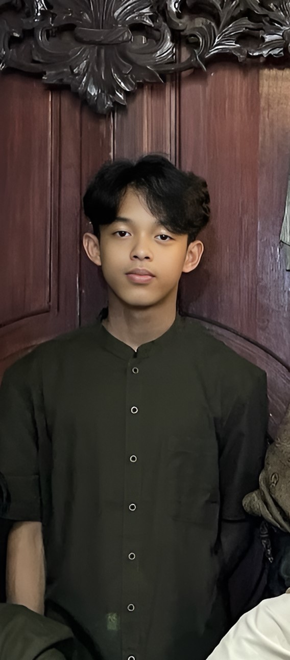 Man in black white and red striped polo shirt standing near gray steel wall